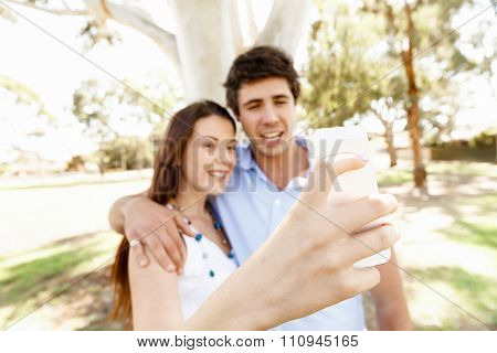 Young couple in the park making their selfi with mobile phone