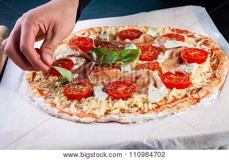 Closeup hand of baker making pizza at kitchen
