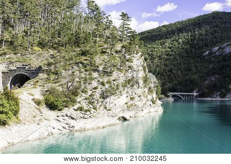 Wooded shore of the lake in French Alps. Lake Castillon is a reservoir in Alpes-de-Haute-Provence in France.