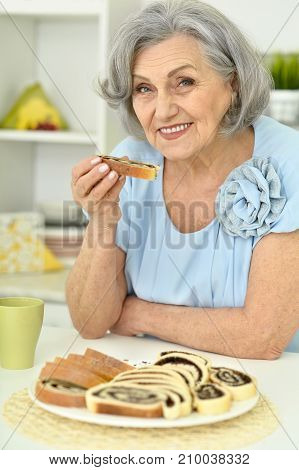 senior woman eating delicious cookies at cookies