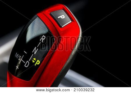 Red Automatic gear stick of a modern car car interior details close up view