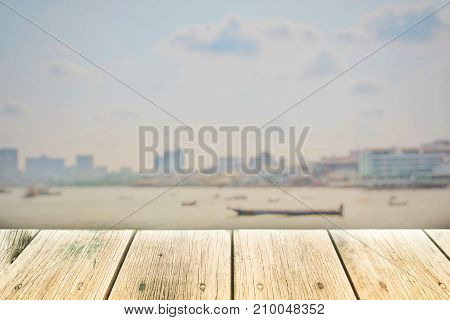 Wood board on defocus cityscape and river view, used for montage or display products among beautiful landscape.