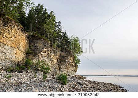 Sunset on the beach. Limestone cliff in the sea under blue sky and white clouds. Kesselaid a small island in Estonia. Nordic countries Europe