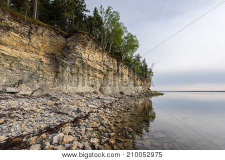 Sunset on the beach. Limestone cliff in the sea under blue sky and white clouds. Kesselaid a small island in Estonia. Nordic countries Europe