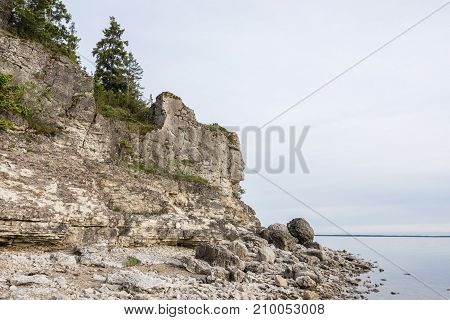 Sunset on the beach. Limestone cliff in the sea under blue sky and white clouds. Kesselaid a small island in Estonia. Nordic countries Europe