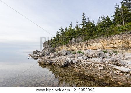 Sunset on the beach. Limestone cliff in the sea under blue sky and white clouds. Kesselaid a small island in Estonia. Nordic countries Europe