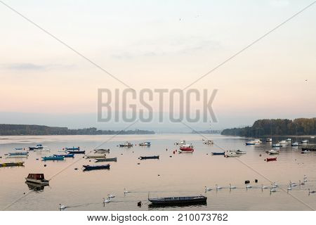 Zemun Quay (Zemunski Kej) in Belgrade Serbia on the Danube river seen in autumn at sunset. Boats can be seen in front and Belgrade center in background