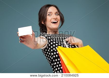 Image Of Good Looking Woman In Speckled Clothes Standing With Purchases And Cutaway In Hands