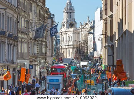 London, UK - March 15, 2017: Busy City of London street with lots of traffic and walking people and St. Paul's cathedral at the background