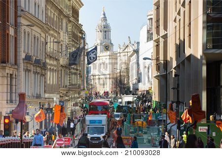 London, UK - March 15, 2017: Busy City of London street with lots of traffic and walking people and St. Paul's cathedral at the background