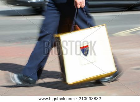 LONDON, UK - June 9, 2017: Blurred image of walking man with shopping bag at Oxford street, the main destination for shopping at Westend.