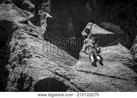 From below panoramic view of man climbing high on mountain