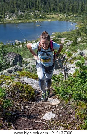 ERGAKI, RUSSIA - AUGUST 05 2017: Unknown girl sportswoman running through the mountains, participant in the trailrunning contest SKAYRANFEST August 5, 2017 in the national park Ergaki, Russia