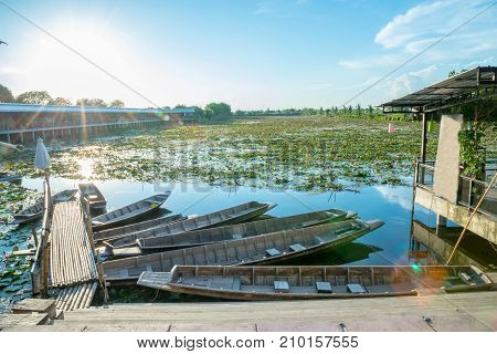 Lotus marsh and wood boat with sky background at Banglane Nakorn pathum Thailand.