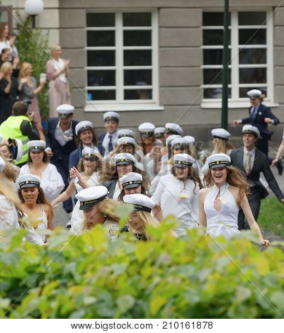 STOCKHOLM SWEDEN - JUN 13 2017: Happy teenagers wearing graduation caps running out from school after graduation at the dance school BalettakademienJune 13 2017StockholmSweden