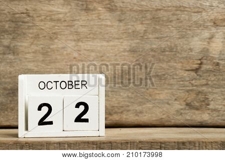 White block calendar present date 22 and month October on wood background (International Stuttering Awareness Day)