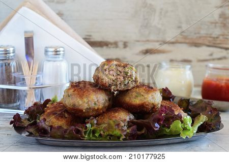 Meatballs with zucchini coated in bread crumbs and panfried. Served with tomato sauce and greek yogurt in glass jars. healthy eating concept