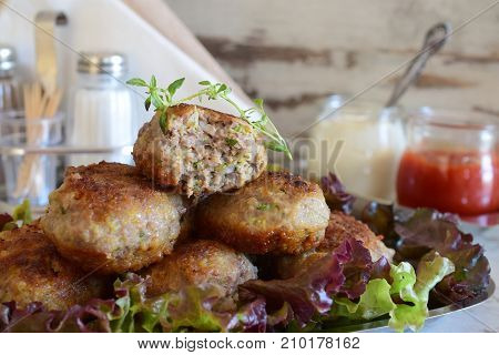 Meatballs with zucchini coated in bread crumbs and panfried. Served with tomato sauce and greek yogurt in glass jars. healthy eating concept