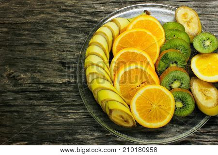 Fresh fruits banana kiwi orange on wooden background. Healthy food. A mix of fresh fruit. Group of citrus fruits. Vegetarian raw fruit. Nutrition for a healthy lifestyle.