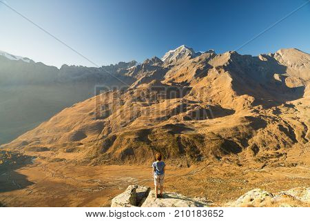 One Person Looking At View High Up On The Alps. Expasive Landscape, Idyllic View At Sunset. Rear Vie