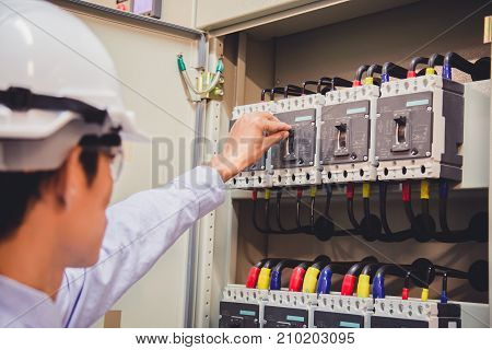 Engineer is check voltage or current by voltmeter in control panel of power plant.