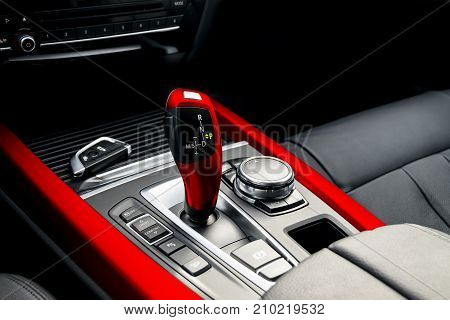 Red automatic gear stick of a modern car car interior details