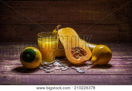 still life with pumpkin and pumpkin juice on a wooden table