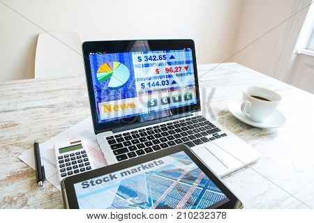 Stock market calculations with a calculator and research software on a Tablet PC with a Laptop computer.