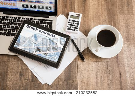 Stock market calculations with a calculator and research software on a Tablet PC with a Laptop computer.