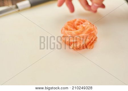 Raw salmon on cutting board. Ingredient for cooking sushi or sashimi. The process of preparing delicious sashimi with salmon.