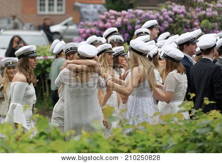 STOCKHOLM SWEDEN - JUN 13 2017: Happy swedish teenagers wearing graduation caps hugging each other after graduation at the dance school BalettakademienJune 13 2017StockholmSweden