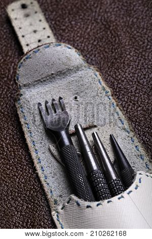 Leather Craft Tools Closeup On A Bordo Leather Background.closeup