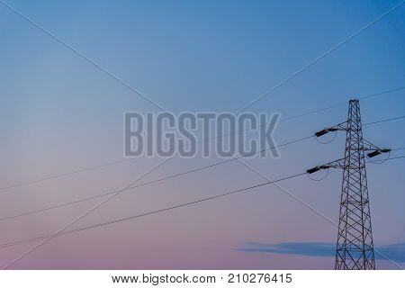 Silhouette of a powerline against clear sky at sunset.