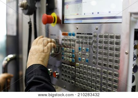 Operator working with controls of the CNC machine. Selective focus.
