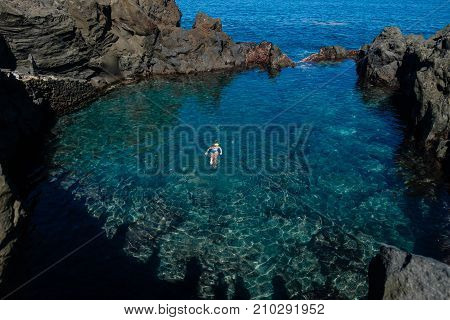 young woman swimming in natural ocean swimming pool on Tenerife island. outdoor shot in Spain. copy space.