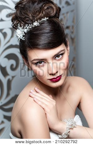 beautiful brunette young woman in white wedding gown. bride with fashion hairstyle. studio shot.