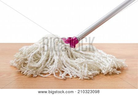 Classic mop with cotton head and metal tubular handle on a wooden floor on a white background
