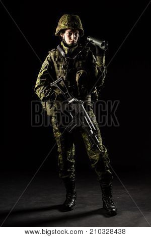 Portrait of armed woman with camouflage. Young female soldier observe with binoculars. Child soldier with gun in war hause ruins background. Military army people concept