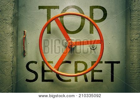 Closed hermetic metallic bunker door with top secret warning