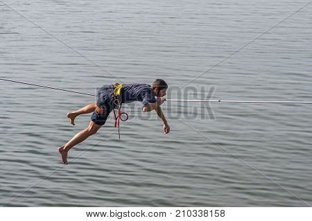 DNIPRO UKRAINE - OCTOBER 01 2016:Young rope-walker is ready to stand up on a rope under Dnipro river in center of the city