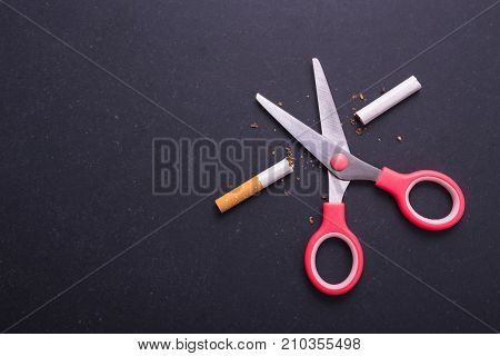 Stop Smoking Concept. Pink Scissor Cut Cigarette In Meaning Stop. Top View On Black Board