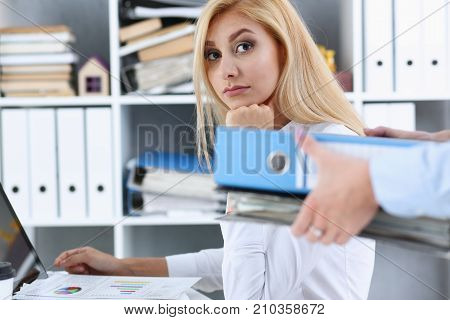 Female employee show pack of documents to busy manager or boss give extra work to executor. White collar portrait contract approval headache and depression irs lot of new problems concept