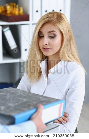 Female employee show pack of documents to busy manager or boss give extra work to executor. White collar portrait contract approval headache and depression irs lot of new problems concept