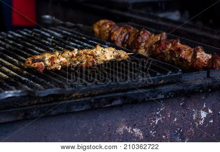 closeup of some meat skewers being grilled in a barbecue