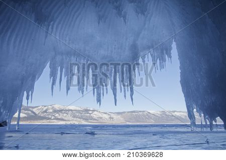 Icicles In Cave. Lake Baikal. Winter Landscape