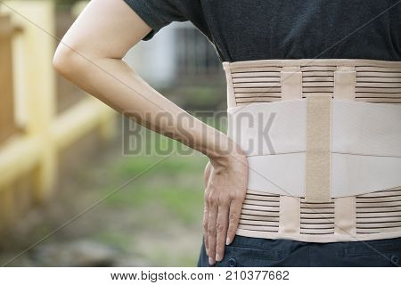 young asian woman wearing back support for protect her back medicine and healthy concept