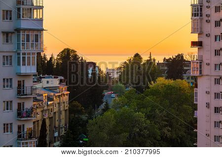 Aerial view of Tonnelnaya street between two apartment buildings and beautiful sea and sky at sunset Sochi Russia