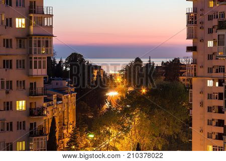 Aerial view of illuminated Tonnelnaya street between two apartment buildings and beautiful sky at twilight Sochi Russia