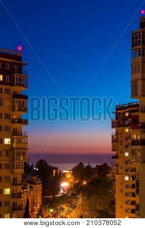 Aerial view of illuminated Tonnelnaya street between two apartment buildings and beautiful sky at twilight Sochi Russia