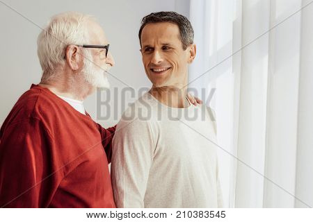 Ask me later. Attractive young man feeling happiness while spending time with his granddaddy